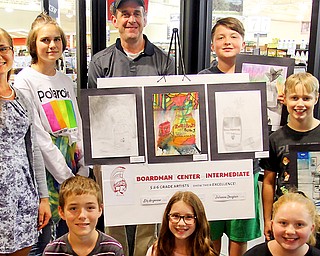 Boardman Intermediate School fifth- and sixth-grade students show off their drawings of Rulli Brothers products at the Rulli Brothers grocery store in Boardman. The images will be hung up inside the store. Front from left are Connor Boots, Julianna Douglass and Kaylee Dennis. Standing from left are art teacher Kate Sears; Lily Anzevino; Michael Rulli, owner; Jimmy Carkido; and Andrew Yantis.  