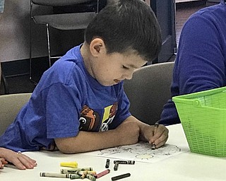 Neighbors | Jessica Harker.Evan Porter colored his picture of an apple tree during the An Apple a Day event at the MetroParks Farms held Sept. 11.