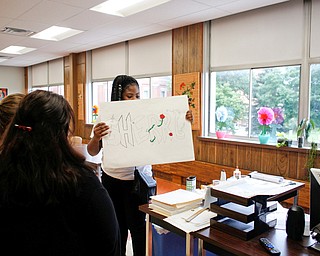 Sherri Wright, a sophomore at Youngstown Rayen Early College High School, shows her tour group one of her art projects during a tour of the new Youngstown Rayen Early College High School on Thursday.