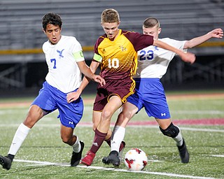 South Range's Canaan Johnson, center, tries to get the ball away from Hubbard's Nader Kassem, left, and Anthony Gagliardi during the first half of their game at South Range on Thursday. EMILY MATTHEWS | THE VINDICATOR