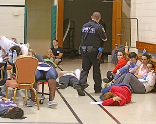  ROBERT K.YOSAY  | THE VINDICATOR..Officer Erik Bateman  works through the injured while searching for more shooters.. The Eagle Joint Fire District in conjunction with the Hubbard City Police, Hubbard TWP Police, other area safety forces  including Mercy Health Hospitals and Trumbull Memorial Hospital, St. PatrickÕs Parish Center in Hubbard, Ohio...