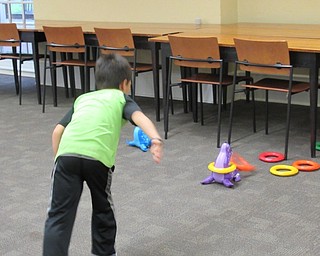 Neighbors | Jessica Harker.Drixson Wibowo played a ring toss game during the Back to School Bash event at the Poland library.