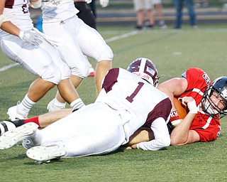 Canfield's Carter Myers holds onto the ball as he gets tackled by Boardman's Mike Fetsko during the first half of their game at Canfield on Friday. EMILY MATTHEWS | THE VINDICATOR