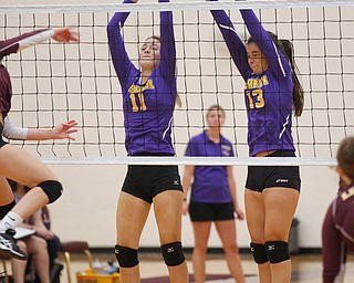 Champion's Grace Mahan (11) and Jacqueline Seman (13) jump to try to block the ball coming from Liberty's Melina Manning during their game at Liberty on Wednesday. EMILY MATTHEWS | THE VINDICATOR