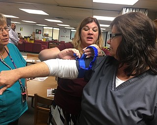 Neighbors | Submitted.Assistant high school principal Anne Botte tightened a tourniquet on school nurse Loraine Cullen Sept. 19 at the Stop the Bleed training at Boardman high school.