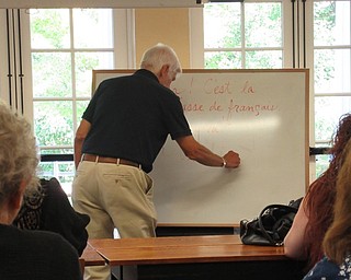 Neighbors | Jessica Harker.Ron Saffell wrote on a white board as part of the first in a series of Conversational French classes.