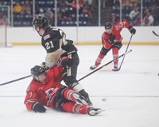 Youngstown's Tristan Amonte falls as the puck gets away from him and Muskegon's Christoffer Bjork during their game at Covelli Centre on Friday night. EMILY MATTHEWS | THE VINDICATOR