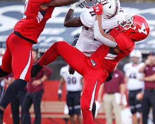 YSU's Devanere Crenshaw, left, and Bryce Gibson tackle Southern Illinois's Raphael Leonard as he tries to catch the ball during the first half of their game at Stambaugh Stadium on Saturday. EMILY MATTHEWS | THE VINDICATOR