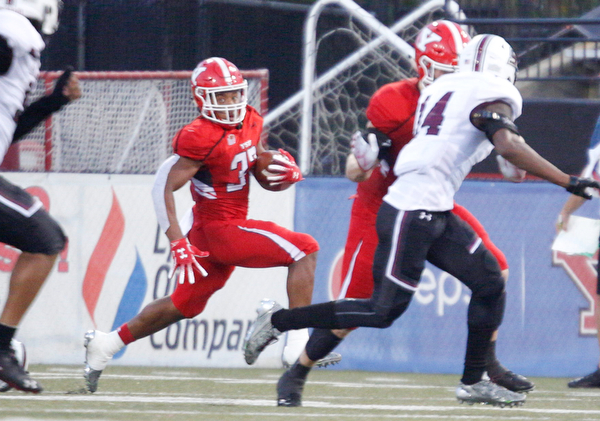 YSU's Tevin McCaster tries to stay away from Southern Illinois as he runs with the ball during the first half of their game at Stambaugh Stadium on Saturday. EMILY MATTHEWS | THE VINDICATOR