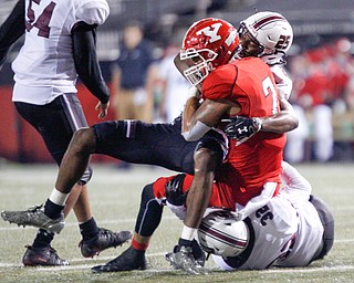 Southern Illinois's Madre Harper and Joe Patterson tackle YSU's Darius Shackleford during the first half of their game at Stambaugh Stadium on Saturday. EMILY MATTHEWS | THE VINDICATOR