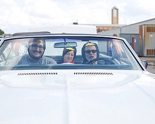 From left, Efrain Velez, a YSU senior studying industrial systems engineering, Rebecca Banks, a 2015 YSU grad and the 2014 homecoming queen, and Marty Cala, a professor of industrial system engineering at YSU, get ready to participate in in the YSU homecoming parade while dressed as penguins on Saturday. EMILY MATTHEWS | THE VINDICATOR