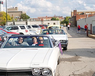 From left, Efrain Velez, a YSU senior studying industrial systems engineering, Rebecca Banks, a 2015 YSU grad and the 2014 homecoming queen, and Marty Cala, a professor of industrial system engineering at YSU, line up with others to participate in in the YSU homecoming parade while dressed as penguins on Saturday. EMILY MATTHEWS | THE VINDICATOR