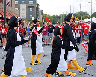 People dressed up like penguins march in the YSU homecoming parade while dressed as penguins on Saturday. EMILY MATTHEWS | THE VINDICATOR