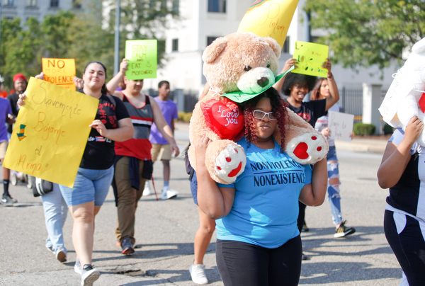 Rashawna Watson, 15, of Youngstown, carries a bear with a sign the says "My Life Matters" as she marches with her family and others in the Nonviolence Week parade on Sunday afternoon. Watson said she and her family participate in the parade every year. EMILY MATTHEWS | THE VINDICATOR
