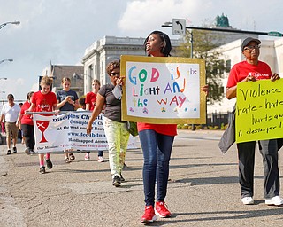 Lela Decembly, left, and Stephanie White, right, both of Bulah Baptist Church in Youngstown, carry signs in the Eighth Annual Nonviolence Week Parade on Sunday afternoon. EMILY MATTHEWS | THE VINDICATOR