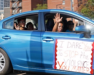 Participants in the Nonviolence Week parade wave from their car as they make their way down Front Street on Sunday afternoon. The parade was the kickoff for Nonviolence week in Youngstown. EMILY MATTHEWS | THE VINDICATOR