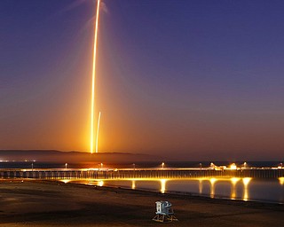 Two streaks in this long exposure photo show a SpaceX Falcon 9 rocket lifting off, left, from Vandenberg Air Force Base, as seen from Pismo Beach, Calif., on Sunday, and then its first stage returning, right, to Earth at a nearby landing pad. The primary purpose of the mission was to place the SAOCOM 1A satellite into orbit, but SpaceX also wanted to expand its recovery of first stages to its launch site at the Air Force base, about 130 miles northwest of Los Angeles.