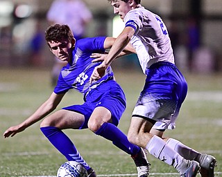 Brennen Testa, left, of Poland Seminary HIgh School, blocks Jacob Gulu of Hubbard High School out of the way to play the ball during the first half of their soccer match Tuesday. Hubbard beat Poland 5-1.