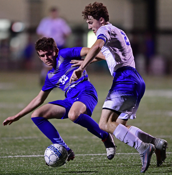 HUBBARD, OHIO - OCTOBER 9, 2018: Poland's Brennen Testa knocks Hubbard's Jacob Gulu out of the way to play the ball during the first half of their game, Tuesday night at Hubbard Eagles Stadium. DAVID DERMER | THE VINDICATOR