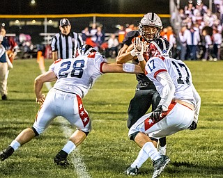 DIANNA OATRIDGE | THE VINDICATOR Howland's Michael Wilson (center) is pursued by Niles' defenders Robbie Savin (28) and Kyle Lundgren (17) as he rushes down the sideline during their game at Lombardo Field on Thursday.