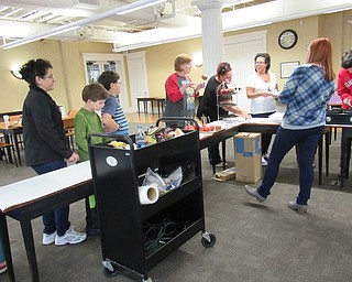 Neighbors | Jessica Harker.Adult programing librarian Missy Williams helped community members through the line to create their gourmet caramel apples at the Poland library on Sept. 29.