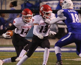 William D. Lewis The Vindicator Struthers' Aiden Hall(14) carries the ball while Keith Burnside(13) blocks as Hubbard's  Kobe Krusik(18) defends during 1rst half action at Hubbard 10-12-18