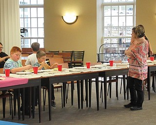 Neighbors | Jessica Harker.Amanda Kollar, children's librarian at the Poland library, helped children paint their canvas' at the Halloween Paint Party on Oct. 2.