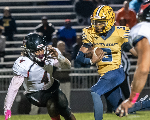 DIANNA OATRIDGE | THE VINDICATOR Youngstown East's Zane Cylar (3) rushes for yardage against defensive pressure from Canfield's Mehlyn Clinkscale (4) during their game at Rayen Stadium in Youngstown on Friday.