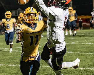 DIANNA OATRIDGE | THE VINDICATOR Canfield's Joe Marzano (9) reaches for a pass against the defense of Youngstown East's Marshall Herron (11) during their game at  Rayen Stadium in Youngstown on Friday.