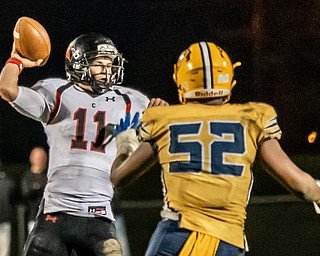 DIANNA OATRIDGE | THE VINDICATOR Canfield quarterback Max Dawson (11) goes back to pass against defensive pressure from Youngstown East's Dawan Martin (52)  during their game at  Rayen Stadium in Youngstown on Friday.