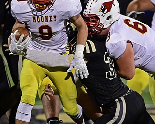 WARREN, OHIO - OCTOBER 12, 2018: Mooney's Jason Santisi right through Harding's Cameren King while picking up a block from a teammate during the first half of their game, Friday night at Warren Harding High School. DAVID DERMER | THE VINDICATOR..63 for Mooney not on roster.