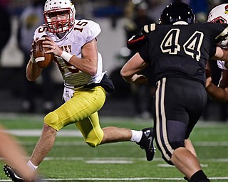 WARREN, OHIO - OCTOBER 12, 2018: Mooney's John Murphy rolls out to pass while being pressured by Harding's Jared Zillinger during the first half of their game, Friday night at Warren Harding High School. DAVID DERMER | THE VINDICATOR