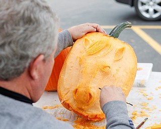 Ron Roberts, of Salem, carves a unicorn into a pumpkin at White House Fruit Farm on Saturday. Roberts said this is his fourth year carving pumpkins for display at White House Fruit Farm. EMILY MATTHEWS | THE VINDICATOR