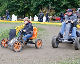 Canaan Ference, 5, and Jay Ference, both of Fowler, race around a track at White House Fruit Farm on Saturday.  EMILY MATTHEWS | THE VINDICATOR