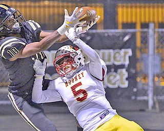 Jakari Salter, left of Warren G. Harding High School, catches a touchdown pass over Nico Marchionda of Cardinal Mooney during the second half of their game Friday night. Harding downed Mooney 19-7.