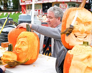 Ron Roberts, of Salem, carves a pumpkin while others he has carved are on display at the annual Fall Festival at White House Fruit Farm, 9249 Youngstown-Salem Road, Canfield.
