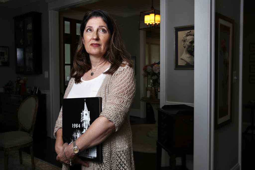 Ruth D-Eredita, holds her college yearbook as she poses for a portrait at her home in Vienna, Va. D-Eredita graduated from Mount Holyoke College in 1984 and last October reported that a professor sexually assaulted her when she was a sophomore in college. Universities have seen an increase in decades-old sexual misconduct complaints amid the #MeToo movement.