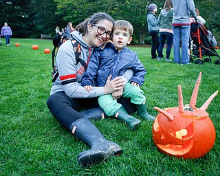 Jenny and Bode Lane, 2, both of Youngstown, pose for a photo with a pumpkin with a carrot mohawk during the Pumpkin Walk at Twilight at Fellows Riverside Gardens on Sunday. EMILY MATTHEWS | THE VINDICATOR