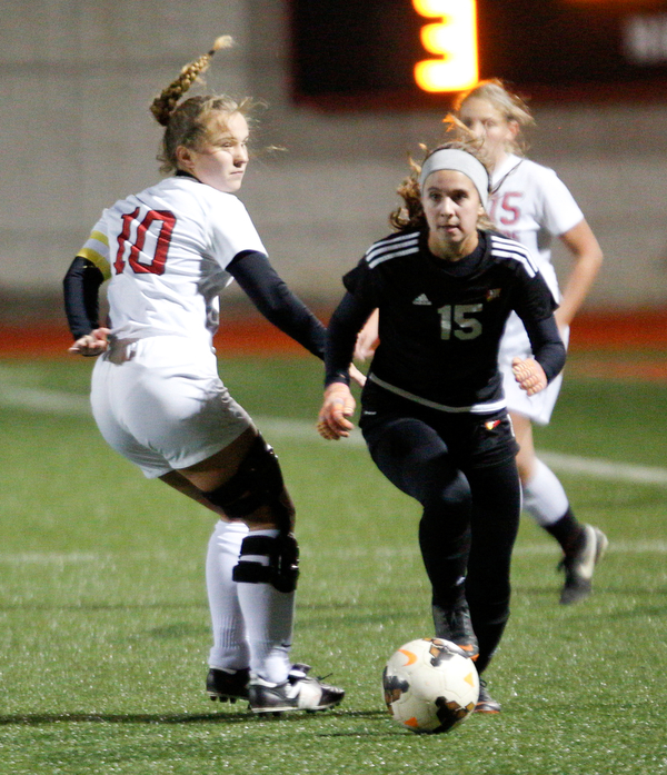 Mooney's Anna Wollet runs the ball past Struthers' Sabrina Bartholomew during their game at Farmers National Bank Soccer Field on Monday. EMILY MATTHEWS | THE VINDICATOR