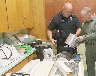 Phil Merlo, left, school resource officer in Boardman schools, and Sgt. Michael Hughes examine the hydroponic lighting the township police department donated to Glenwood Junior High School. The equipment, which was seized in drug raids, will be used in science classes. 