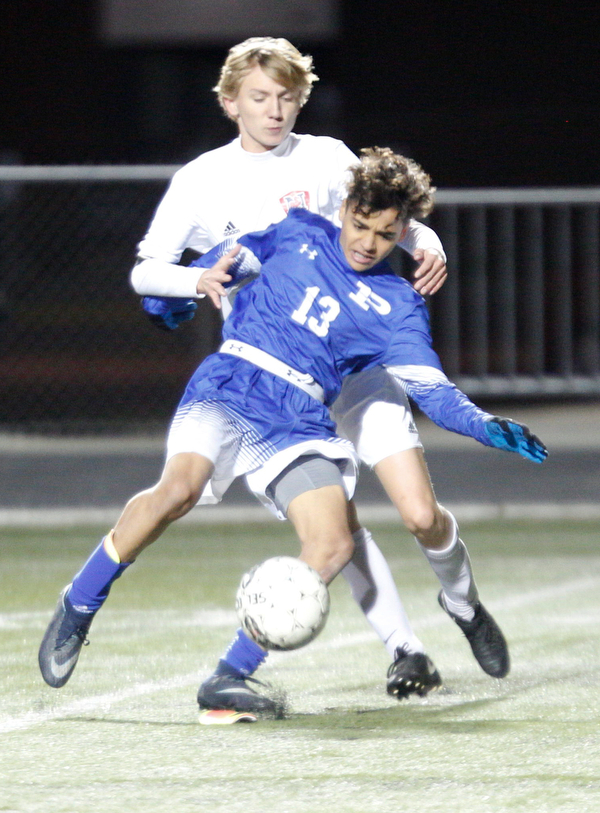 Poland's Justice Gonzalez tries to keep the ball away from Niles' Tristian DelVecchio during the first half of their game at Poland on Tuesday. EMILY MATTHEWS | THE VINDICATOR