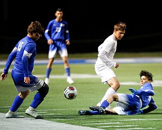 Poland's Justice Gonzalez slides to get the ball away from Niles' Chance Jerome and to Poland's Bailey Swogger during the first half of their game at Poland on Tuesday. EMILY MATTHEWS | THE VINDICATOR