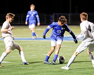 Poland's Justice Gonzalez tries to keep the ball away from Niles' Casey Flynn, left, and Sam Reigle during the first half of their game at Poland on Tuesday. EMILY MATTHEWS | THE VINDICATOR