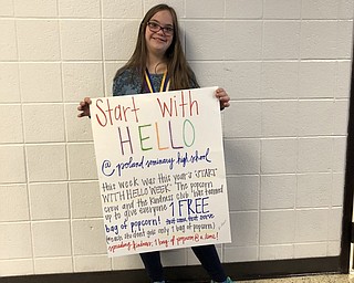 Neighbors | Submitted.Christin Murcko, a member of the kindness club at Poland high school, held a sign displaying the Start With Hello week plan to give one free bag of popcorn to students at the school.