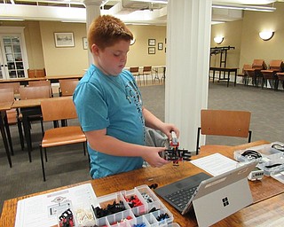 Neighbors | Jessica Harker.Israel Zink worked to finish the gripper portion of the Lego Mindstorm GRIPP3R robot at the Poland library Oct. 11.