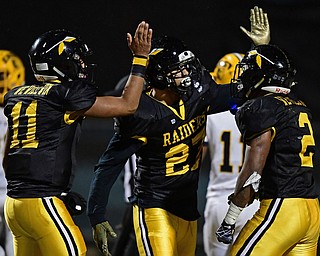 WARREN, OHIO - OCTOBER 19, 2018: Harding's Elijah Smith, center, is congratulated by Kayron Adams, right, and Elijah Taylor, left, after scoring a touchdown during the second half of their game, Friday night at Warren Harding High School. DAVID DERMER | THE VINDICATOR