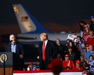 Rep. Greg Gianforte, R-Mont., speaks as President Donald Trump stands near him during a campaign rally at Minuteman Aviation Hangar. Trump attended the event Thursday in Missoula, Mont. 