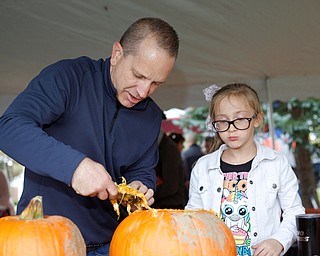 Matthew Day, left, and his daughter Abigail Day, 8, both of East Palestine, start to carve a pumpkin at the Canfield Police Department's Fall Festival on Saturday. EMILY MATTHEWS | THE VINDICATOR