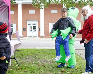 Krista Ventresco, right, of Austintown, tries to convince her grandson James Rounds Jr., 3, of Austintown, left, to get his photo taken with Chris Colucci, 13, of Greenford, in his alien costume at the Canfield Police Department's Fall Festival on Saturday. EMILY MATTHEWS | THE VINDICATOR