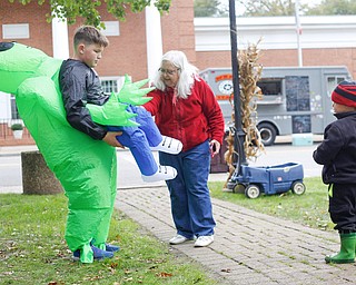 Krista Ventresco, center, of Austintown, tries to convince her grandson James Rounds Jr., 3, of Austintown, right, to get his photo taken with Chris Colucci, 13, of Greenford, in his alien costume at the Canfield Police Department's Fall Festival on Saturday. EMILY MATTHEWS | THE VINDICATOR